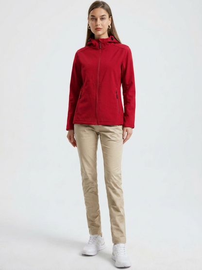 Red - A woman wearing a structured olive green matte technical hooded jacket with a front zip closure, panelled seam detailing, and zippered pockets, paired with beige trousers.