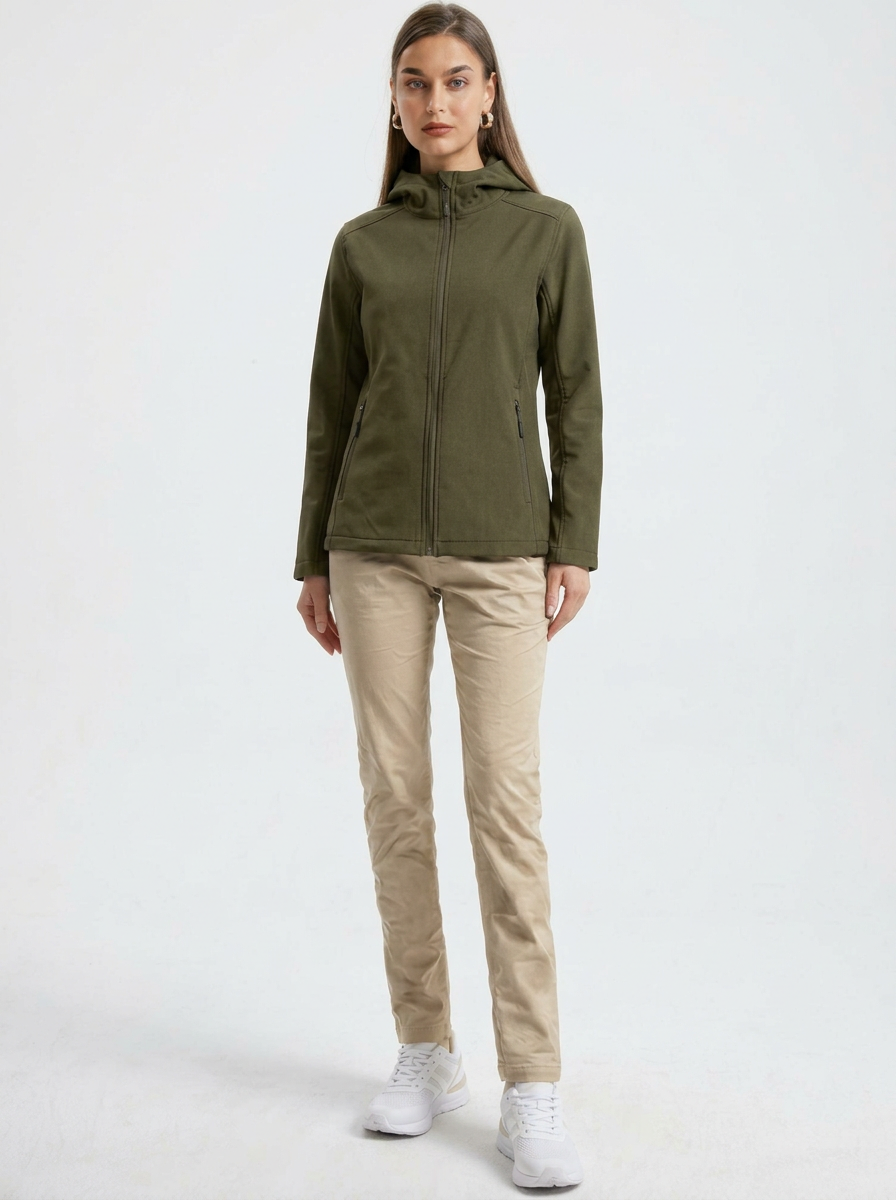 Green - A woman wearing a structured olive green matte technical hooded jacket with a front zip closure, panelled seam detailing, and zippered pockets, paired with beige trousers.
