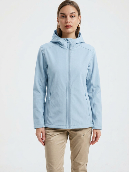 Blue - A woman wearing a structured olive green matte technical hooded jacket with a front zip closure, panelled seam detailing, and zippered pockets, paired with beige trousers.