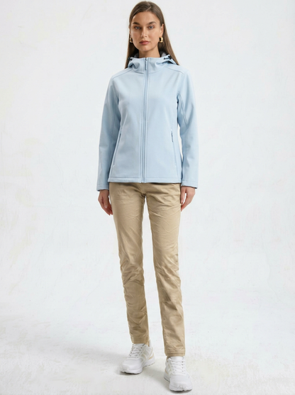 Blue - A woman wearing a structured olive green matte technical hooded jacket with a front zip closure, panelled seam detailing, and zippered pockets, paired with beige trousers.