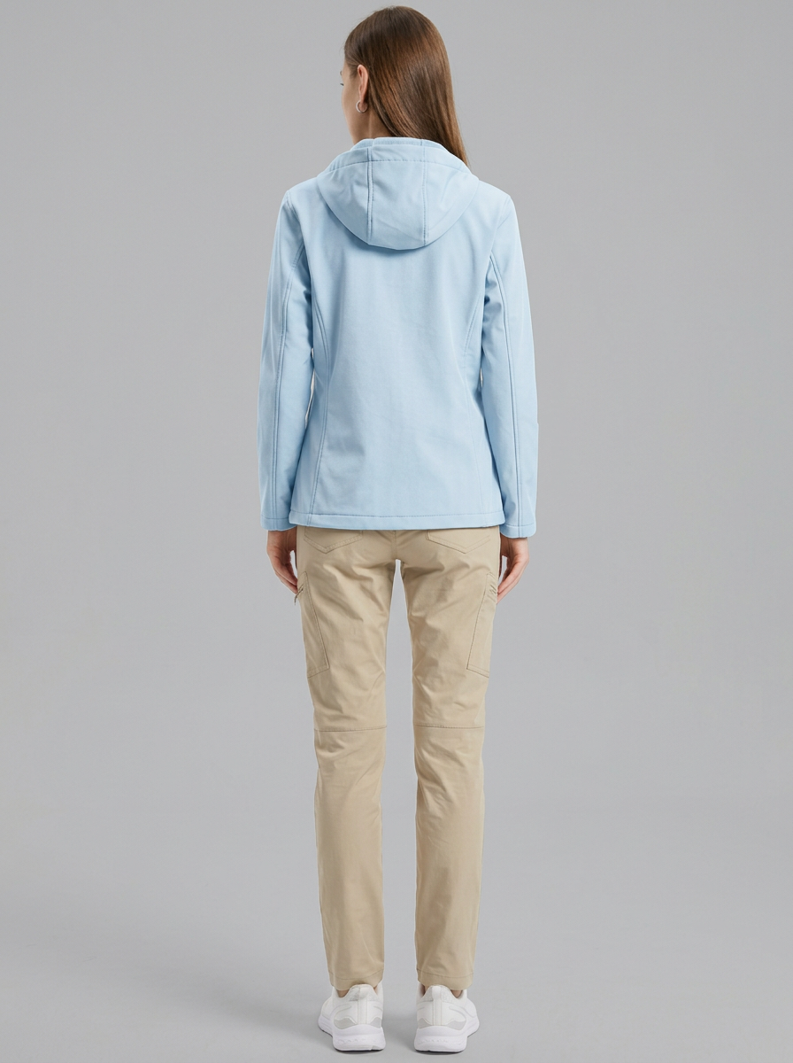 Blue - A woman wearing a structured olive green matte technical hooded jacket with a front zip closure, panelled seam detailing, and zippered pockets, paired with beige trousers.