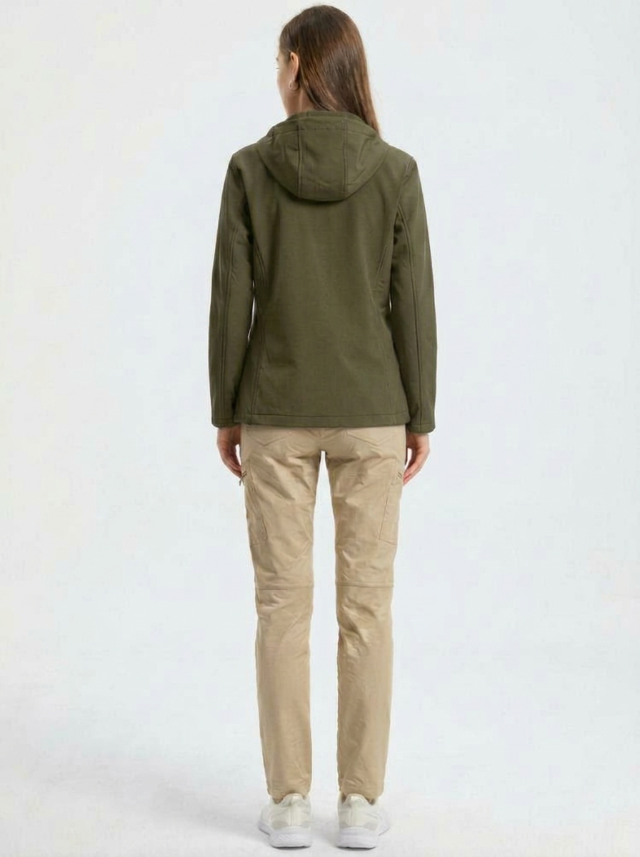 Green - A woman wearing a structured olive green matte technical hooded jacket with a front zip closure, panelled seam detailing, and zippered pockets, paired with beige trousers.