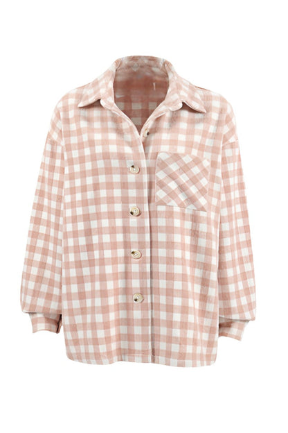 A woman taking a mirror selfie wearing an oversized, light pink and white plaid shacket over a white crop top and light wash denim jeans.