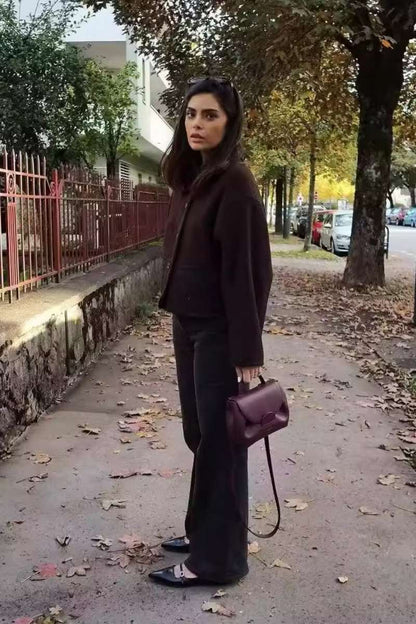 A woman wearing a dark brown, heavyweight textured cropped jacket with an oversized fit, button-front closure, and dropped shoulders, styled casually with dark denim.