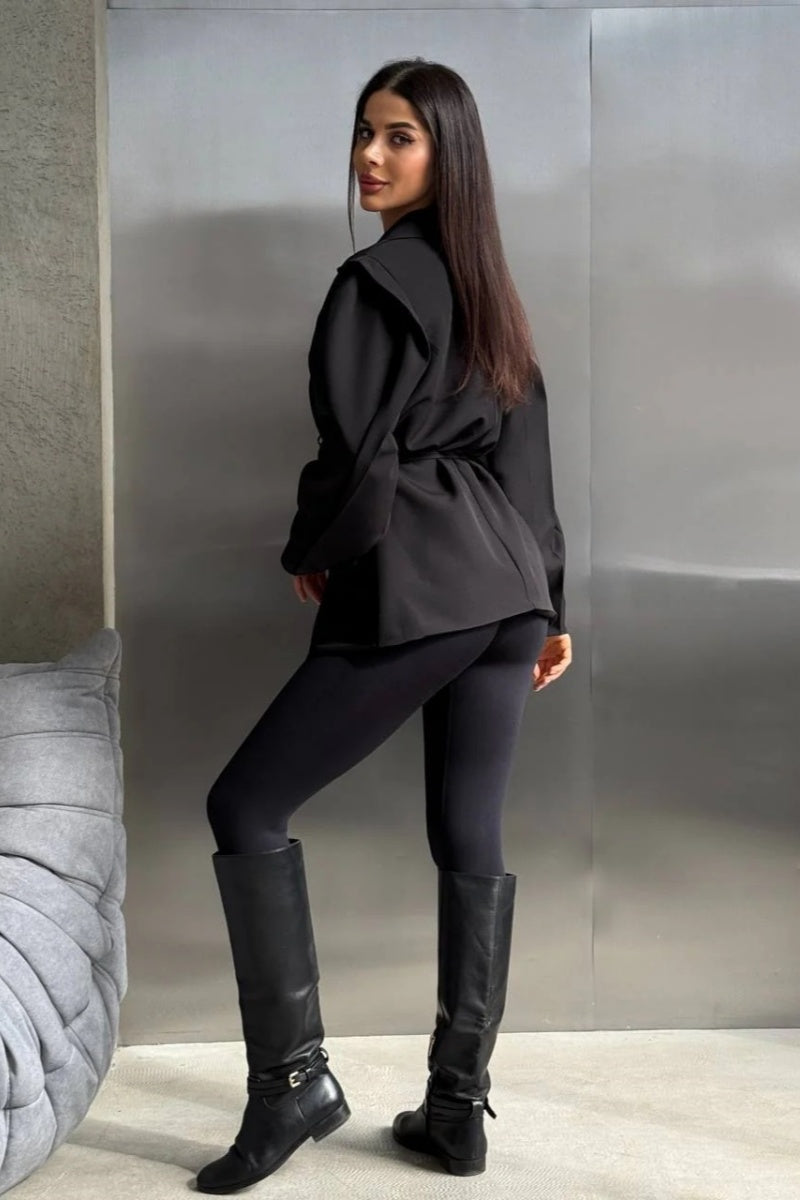 Black - Woman wearing a black oversized blazer with structured shoulders and a tie waist, paired with black leggings and knee-high boots.