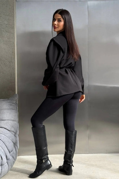 Black - Woman wearing a black oversized blazer with structured shoulders and a tie waist, paired with black leggings and knee-high boots.