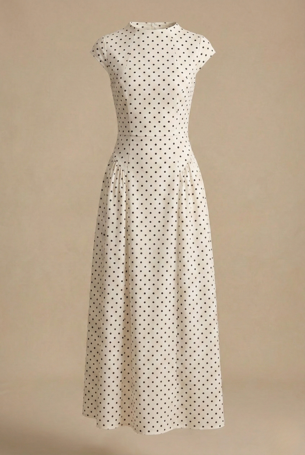 White - Model wearing a white and black polka dot maxi dress featuring a high neckline, cap sleeves, a fitted bodice with a basque waist, and a full pleated A-line skirt.