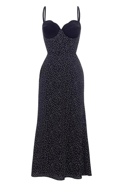Black - A woman models a black formal maxi dress featuring a velvet sweetheart bustier, spaghetti straps, and an all-over white polka dot pattern.