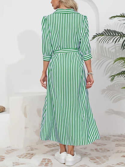 Woman wearing a striped poplin midi shirt dress with 3/4 sleeves, a collared neckline, and a tie waist, styled with white trainers.
