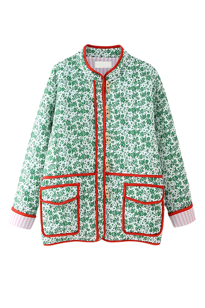 Green - Woman wearing a green and white ditsy floral quilted jacket with red piped trim over a pink striped dress.