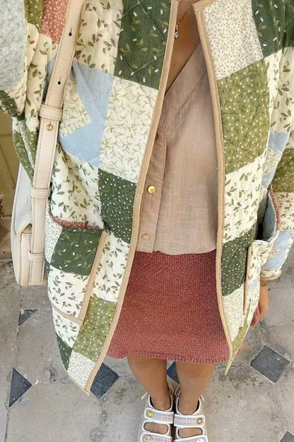 A woman wearing a quilted patchwork jacket with floral and solid panels, styled over a beige shirt and pink textured mini skirt.