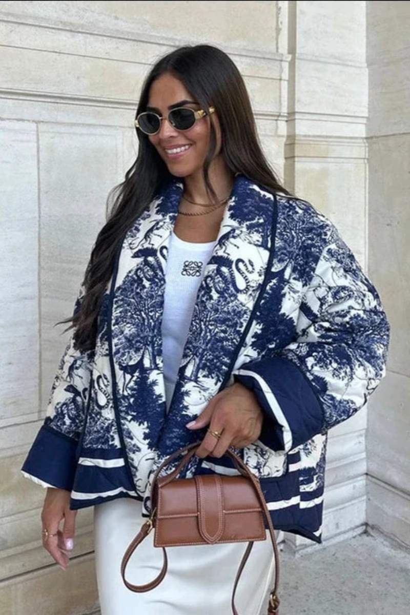 Women's oversized quilted jacket featuring a navy and white toile scenic print, open front, and contrast striped borders on the wide sleeves and hem.