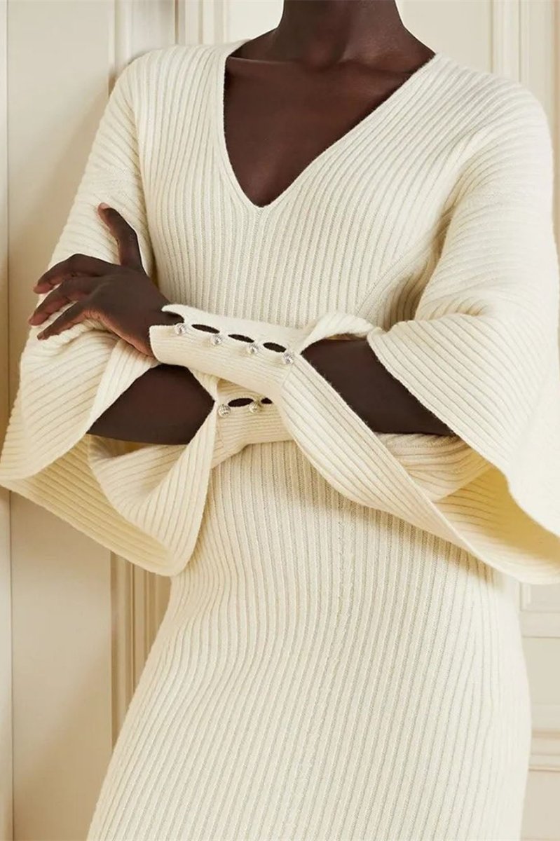 White - Model wearing a ribbed knit V-neck midi dress featuring dramatic split flared sleeves and a fitted silhouette.