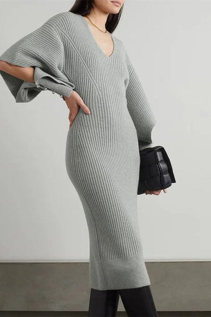 Grey - Model wearing a ribbed knit V-neck midi dress featuring dramatic split flared sleeves and a fitted silhouette.