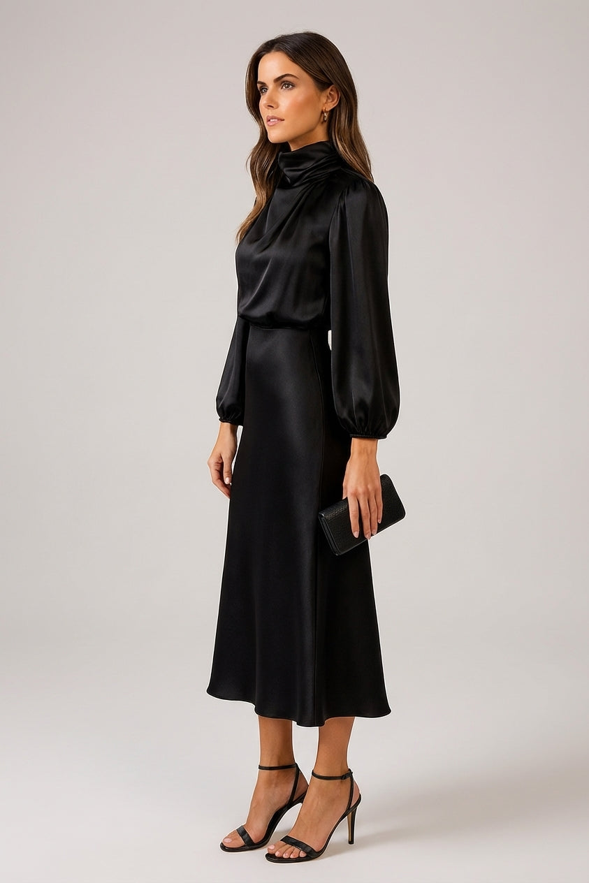Black - A woman wearing a champagne-coloured satin midi dress with a high neckline, long balloon sleeves, and an elasticated waist, posing against a neutral grey background.