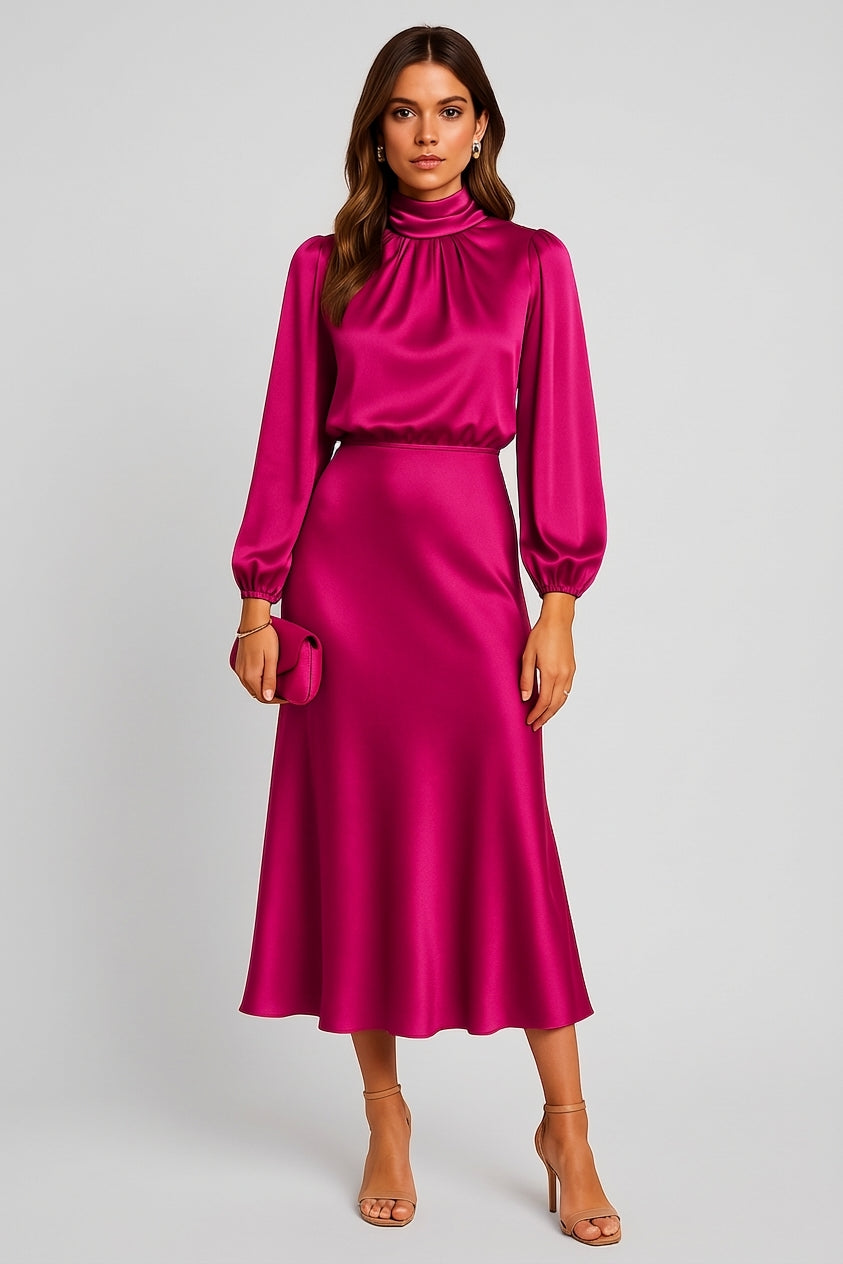 Hot Pink - A woman wearing a champagne-coloured satin midi dress with a high neckline, long balloon sleeves, and an elasticated waist, posing against a neutral grey background.