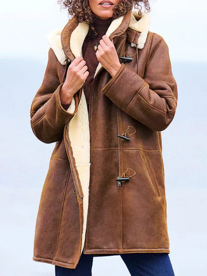 Brown - A woman wearing a mid-length brown textured suede-look coat with a plush cream shearling lining, featuring a hood, toggle closures, and a front zipper.