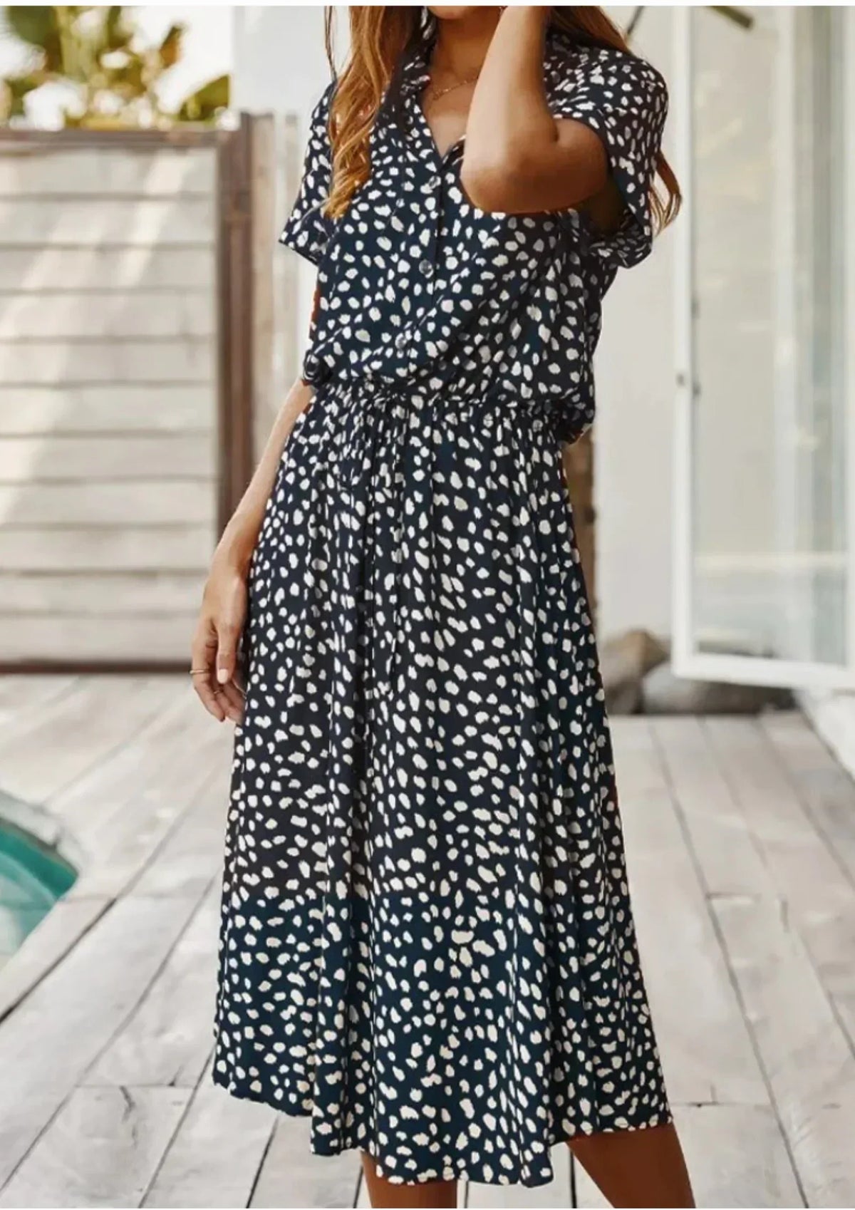 Deep Blue - Woman wearing a white midi shirt dress with a brown abstract spotted print, featuring a collared button-front bodice and a drawstring waist.