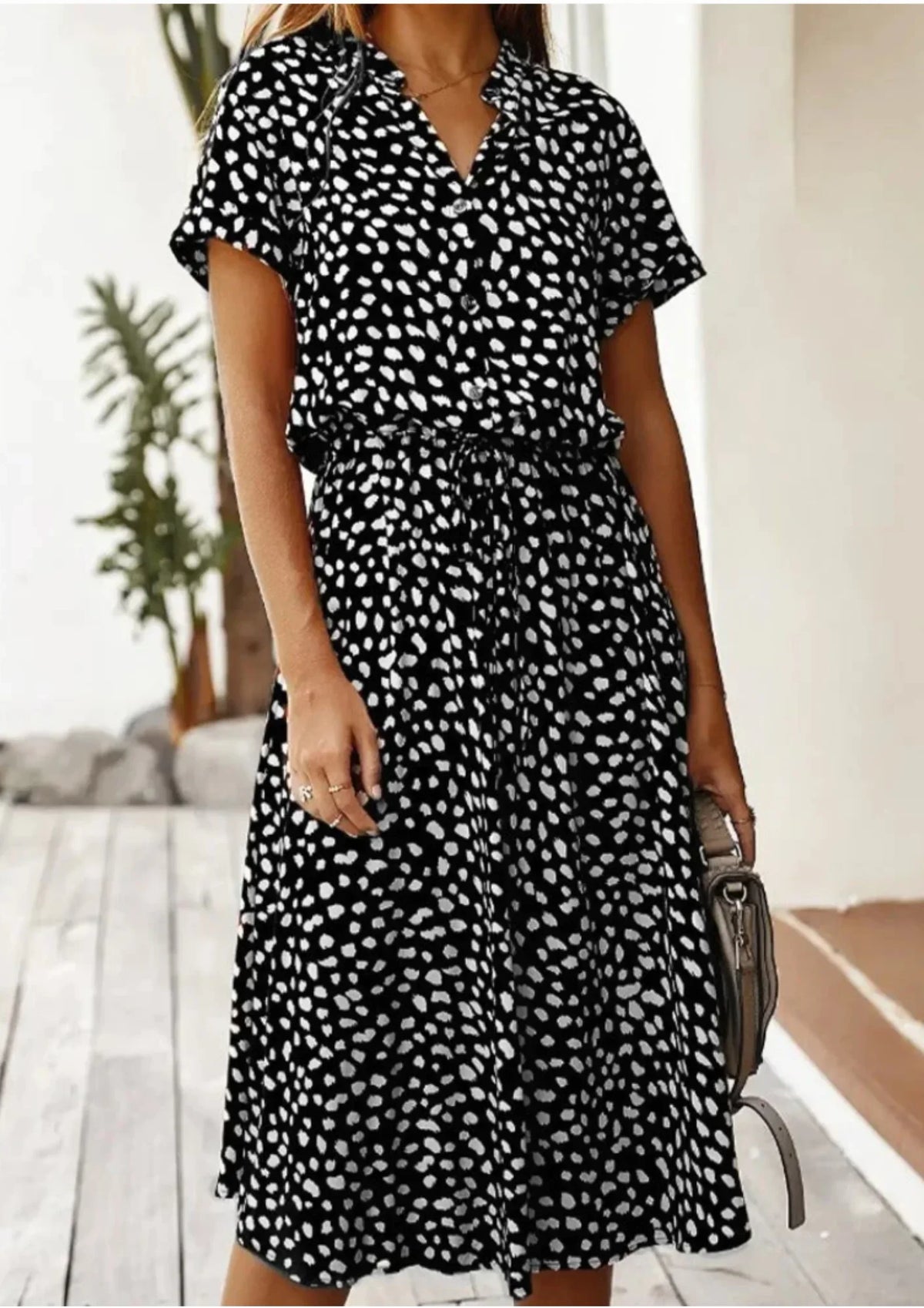 Black - Woman wearing a white midi shirt dress with a brown abstract spotted print, featuring a collared button-front bodice and a drawstring waist.