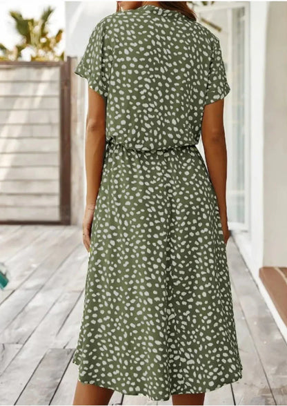 Green - Woman wearing a white midi shirt dress with a brown abstract spotted print, featuring a collared button-front bodice and a drawstring waist.