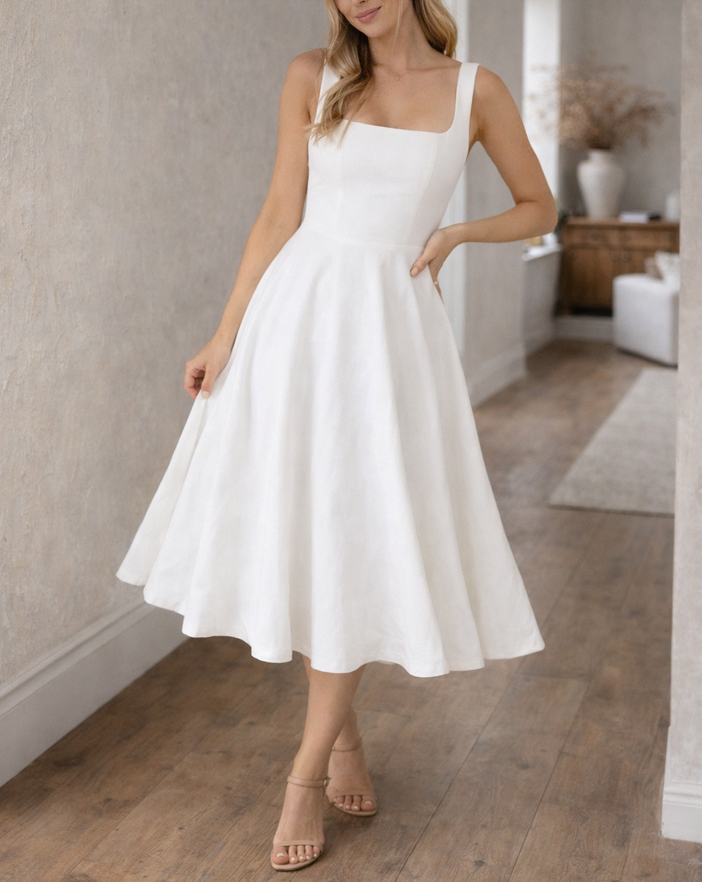 Black - A woman wearing a structured white textured crepe midi dress with a square neckline, wide straps, a fitted bodice, and a voluminous A-line skirt with side pockets.