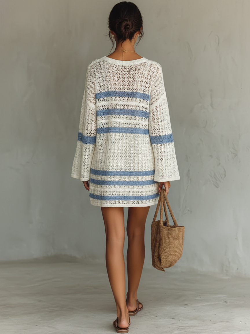 White - A person wearing a cream and blue striped open-knit crochet mini dress with wide long sleeves, holding a woven tote bag.