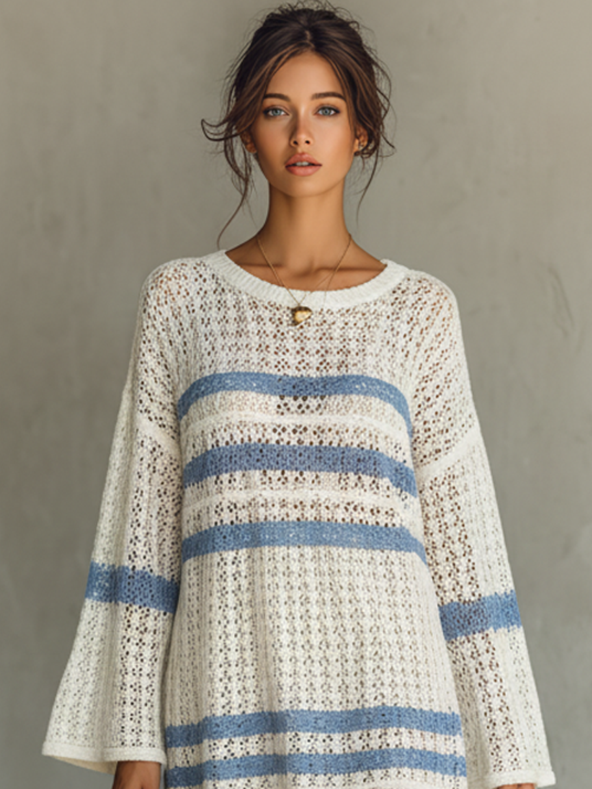 White - A person wearing a cream and blue striped open-knit crochet mini dress with wide long sleeves, holding a woven tote bag.