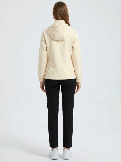 White - A woman wearing a cream-coloured structured hooded jacket with a contrast black front zipper, elasticised cuffs, and side pockets, paired with black pants.