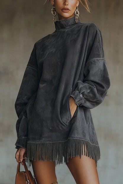 Model wearing a relaxed fit faux-suede mini dress featuring a high turtleneck, dropped long sleeves, front pockets, and a long fringe hemline.