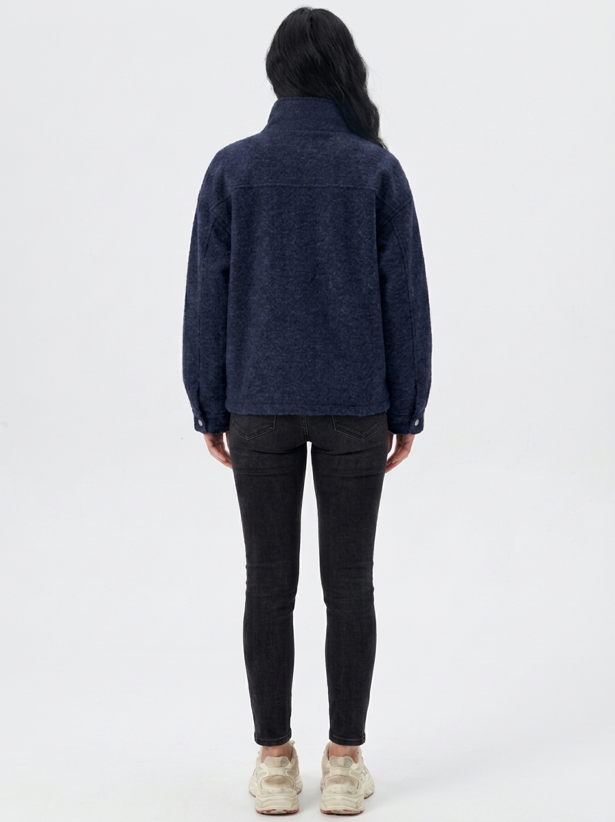Navy - A woman wearing a dark navy blue textured jacket with a high stand collar lined in contrast cream fleece, featuring a snap-button front closure and a relaxed fit.