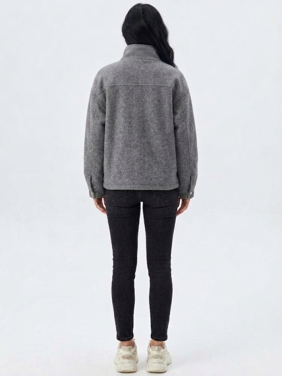 Gray - A woman wearing a dark navy blue textured jacket with a high stand collar lined in contrast cream fleece, featuring a snap-button front closure and a relaxed fit.