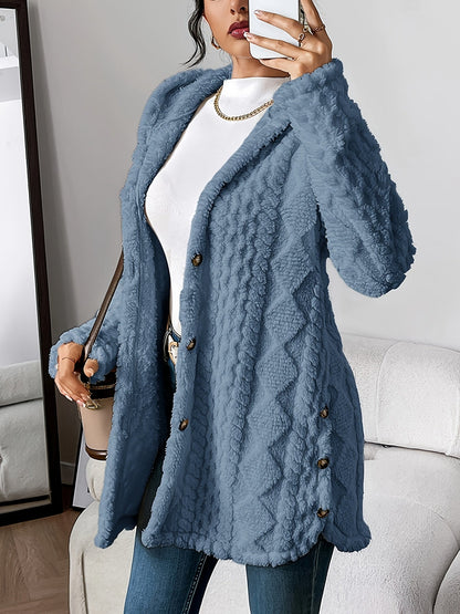 Denim Blue - A woman wearing a beige, mid-length textured fleece hooded jacket with a diamond pattern, button closure, and buttoned side vents, layered over a white high-neck top and blue jeans.
