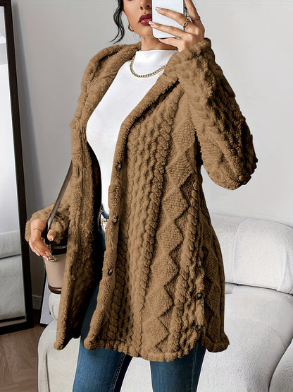 Black - A woman wearing a beige, mid-length textured fleece hooded jacket with a diamond pattern, button closure, and buttoned side vents, layered over a white high-neck top and blue jeans.