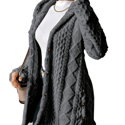 Grey - A woman wearing a beige, mid-length textured fleece hooded jacket with a diamond pattern, button closure, and buttoned side vents, layered over a white high-neck top and blue jeans.