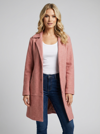 Pink - A woman wearing a textured green mid-length coat with a notch lapel, single-breasted buttons, and cuffed sleeves, styled over a white top and dark grey jeans.