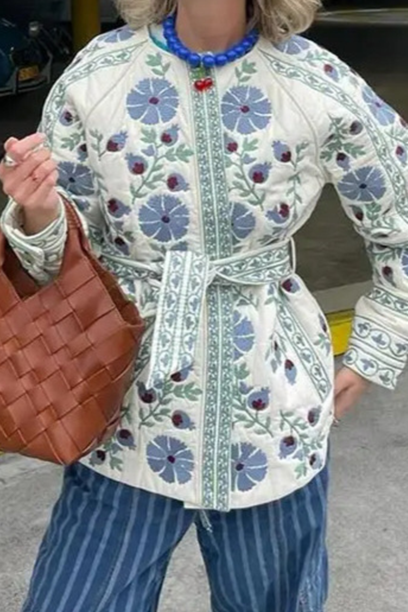 Blue - Women's cream mid-length jacket featuring blue and burgundy floral embroidery, a matching tie-waist belt, and button-front closure, styled over denim.