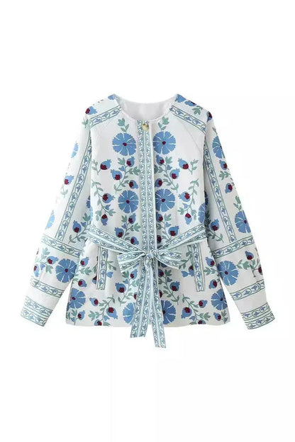 Blue - Women's cream mid-length jacket featuring blue and burgundy floral embroidery, a matching tie-waist belt, and button-front closure, styled over denim.