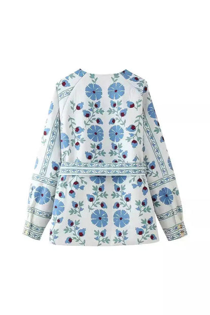 Blue - Women's cream mid-length jacket featuring blue and burgundy floral embroidery, a matching tie-waist belt, and button-front closure, styled over denim.