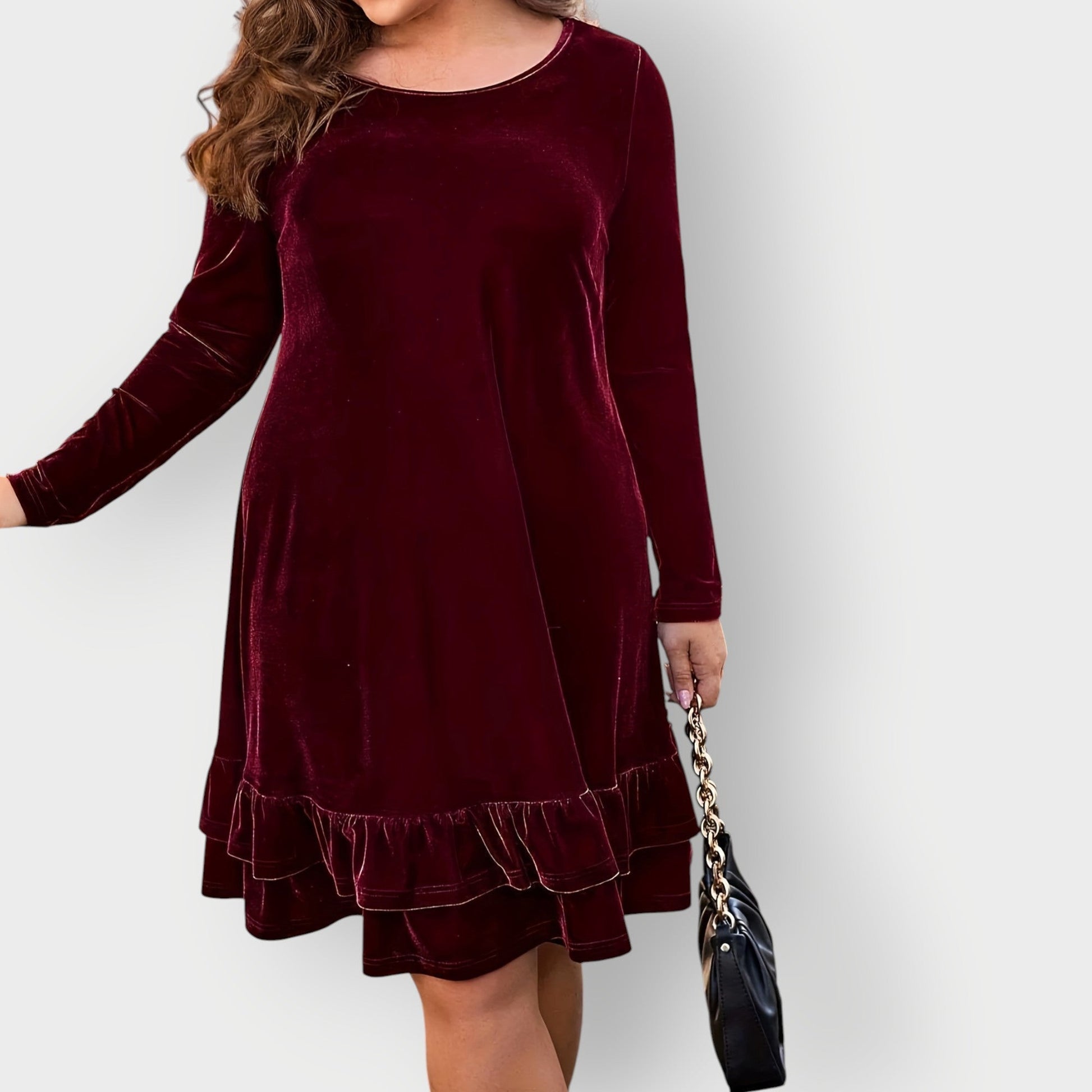 Violet - Woman wearing a solid long sleeve velvet A-line dress featuring a double tiered ruffle hem