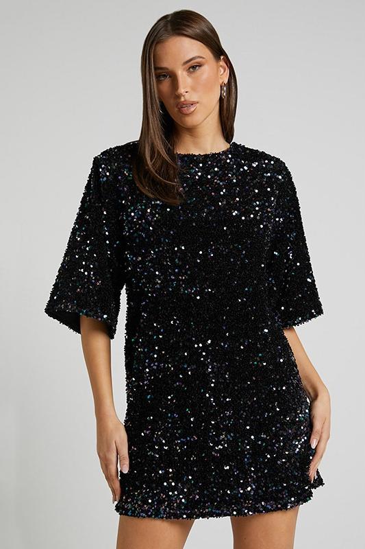 Woman wearing a pink sequin mini dress with open back