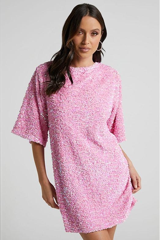 Woman wearing a pink sequin mini dress with open back