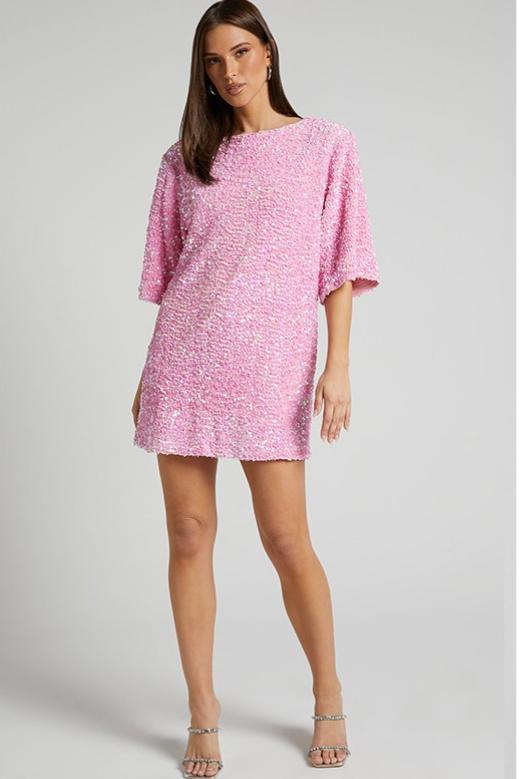 Woman wearing a pink sequin mini dress with open back