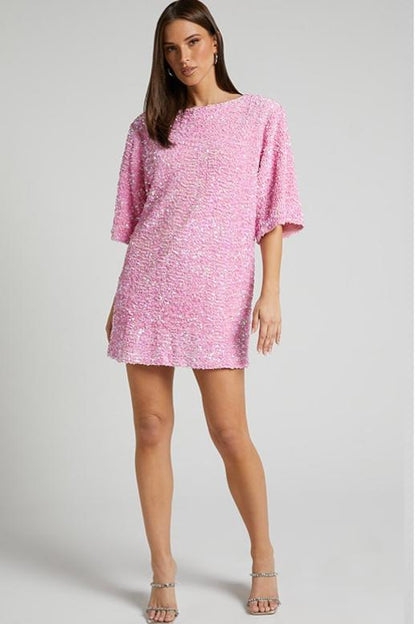 Woman wearing a pink sequin mini dress with open back