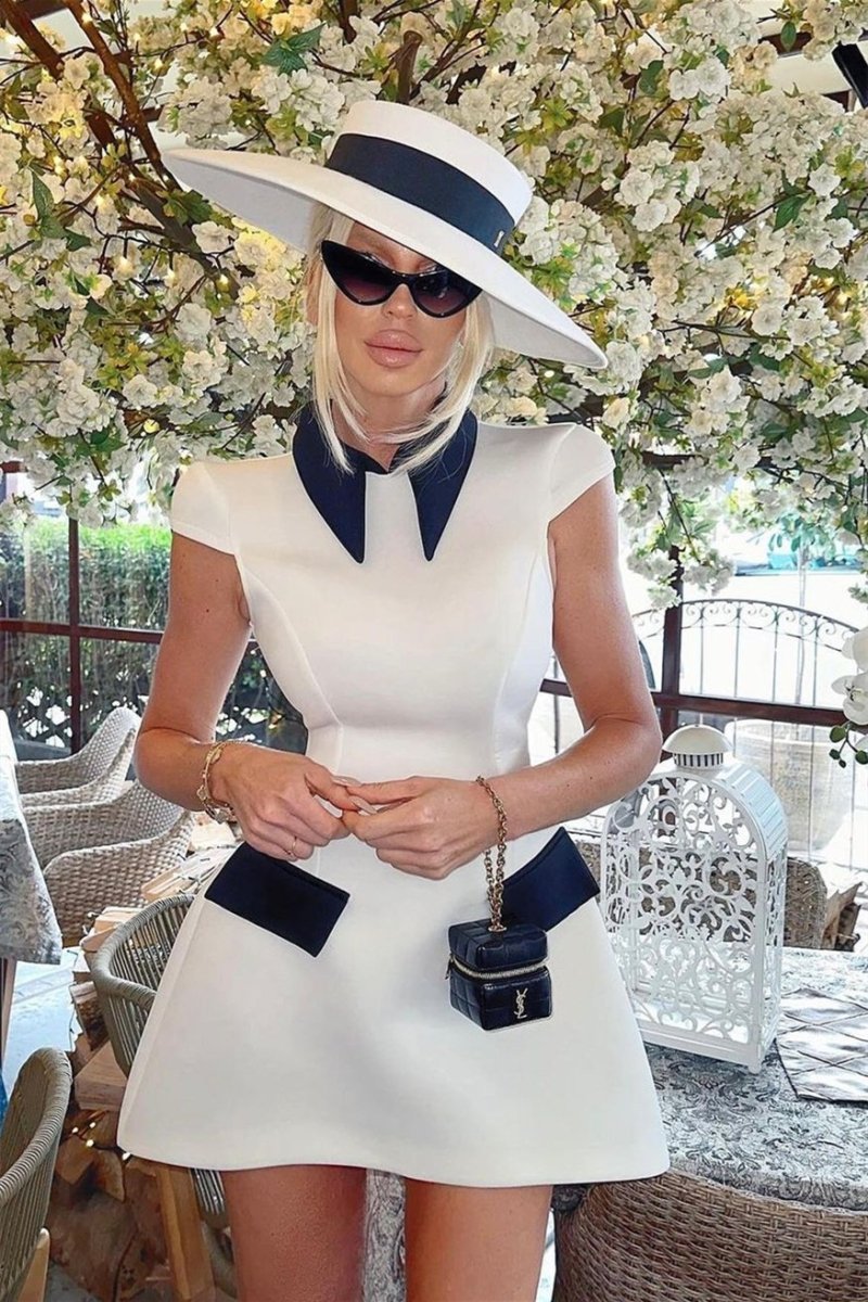Woman in white mini dress with black collar and pockets