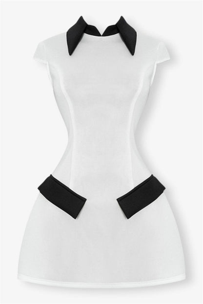 Woman in white mini dress with black collar and pockets