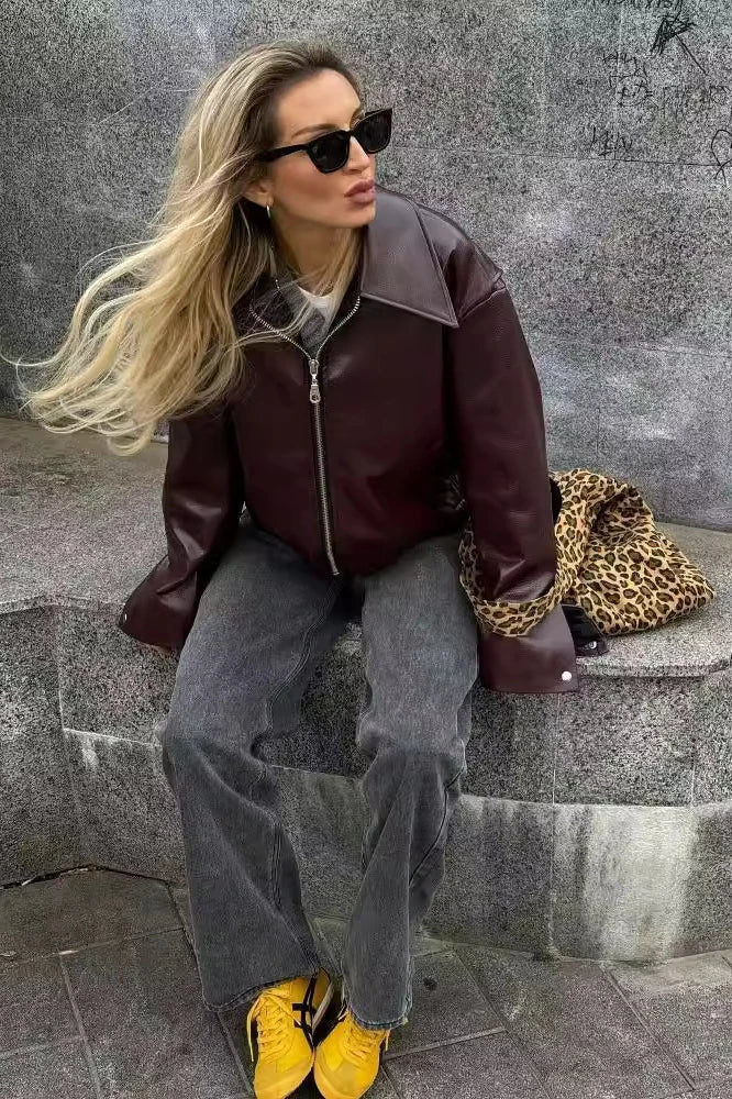 Amaranth - Women's deep burgundy faux leather zip-front cropped bomber jacket with a wide collar, styled over a black top and dark denim.